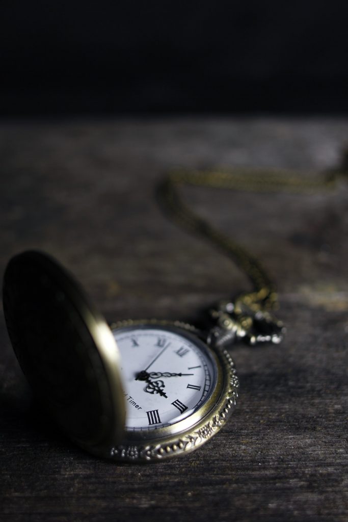 an antique gold chain watch on the dark surface