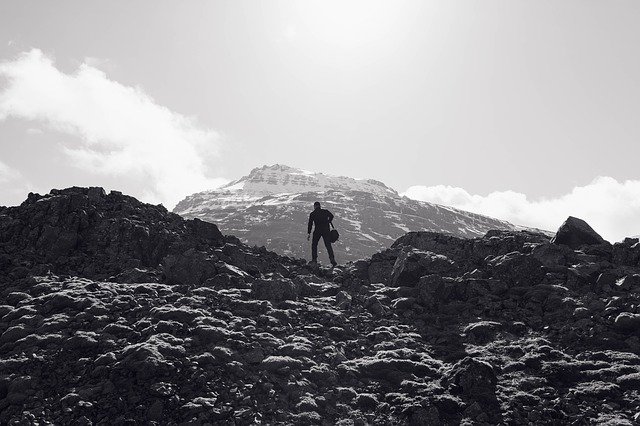 A man on a perilous journey toward a mountaintop.